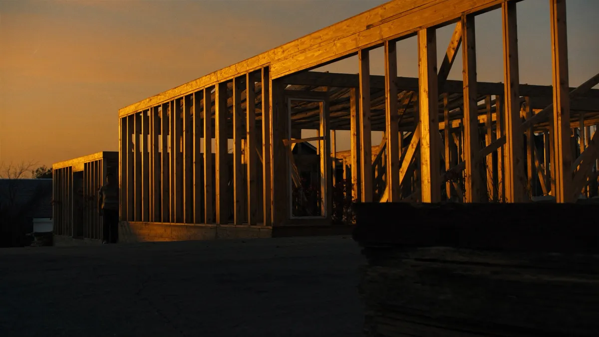 Structural framing crew building a luxury custom home in Toronto — engineered lumber and steel under a winter sky